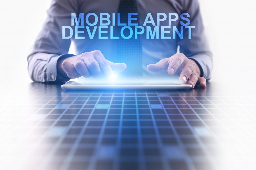 Businessman using tablet pc and select Mobile apps development.